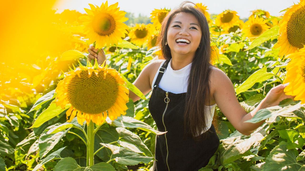 Asian Girl Laughing in Sunflower Field